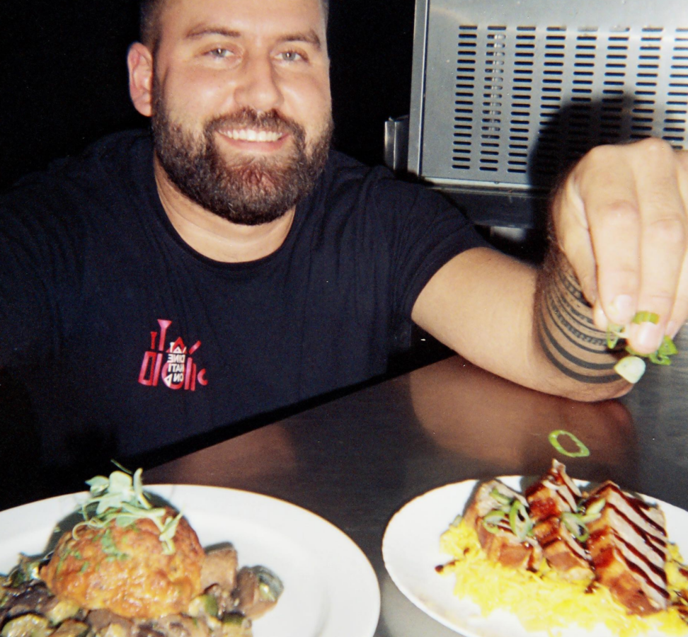 Smiling chef at the food truck counter with two plates in front