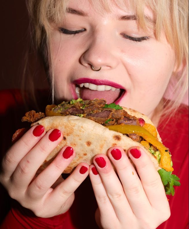Woman biting into a loaded wrap
